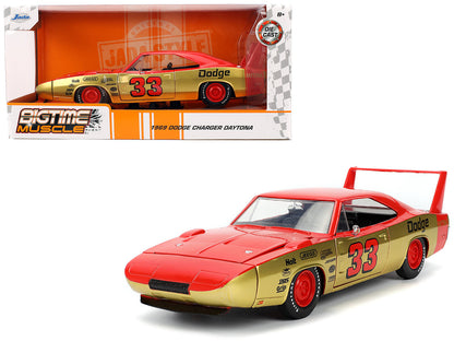 1969 Dodge Charger Daytona model car with gold and red design, featuring the number 33, in front of its packaging.